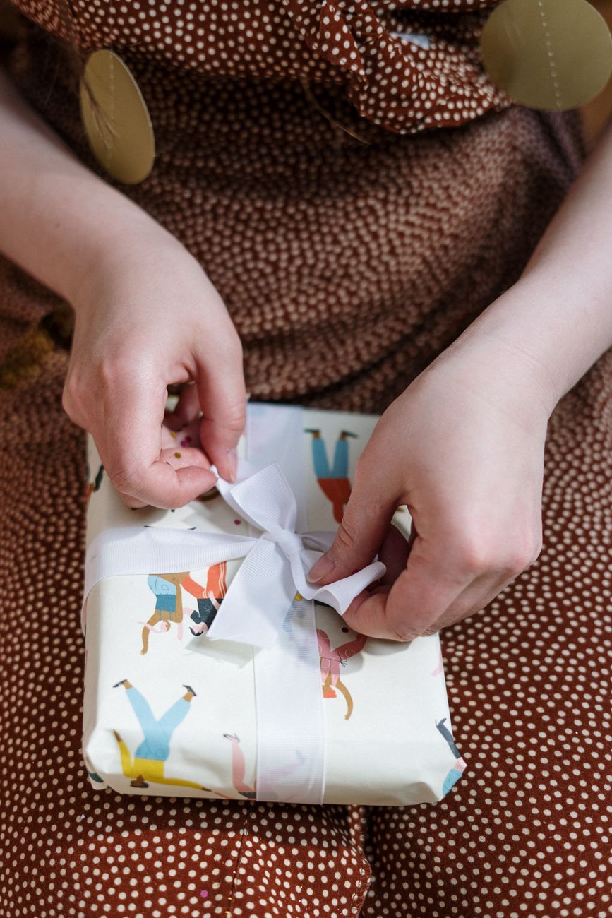 Hands wrapping a small gift